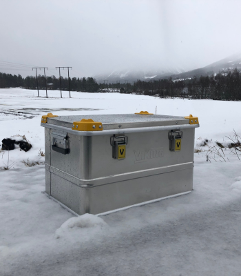 Viking aluminium kist geplaatst in een besneeuwd landschap, met metalen sluitingen en gele hoekbeschermers zichtbaar.